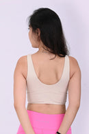 Back view of a person wearing a BELVYNN premium cream white sports bra and pink leggings on a white background