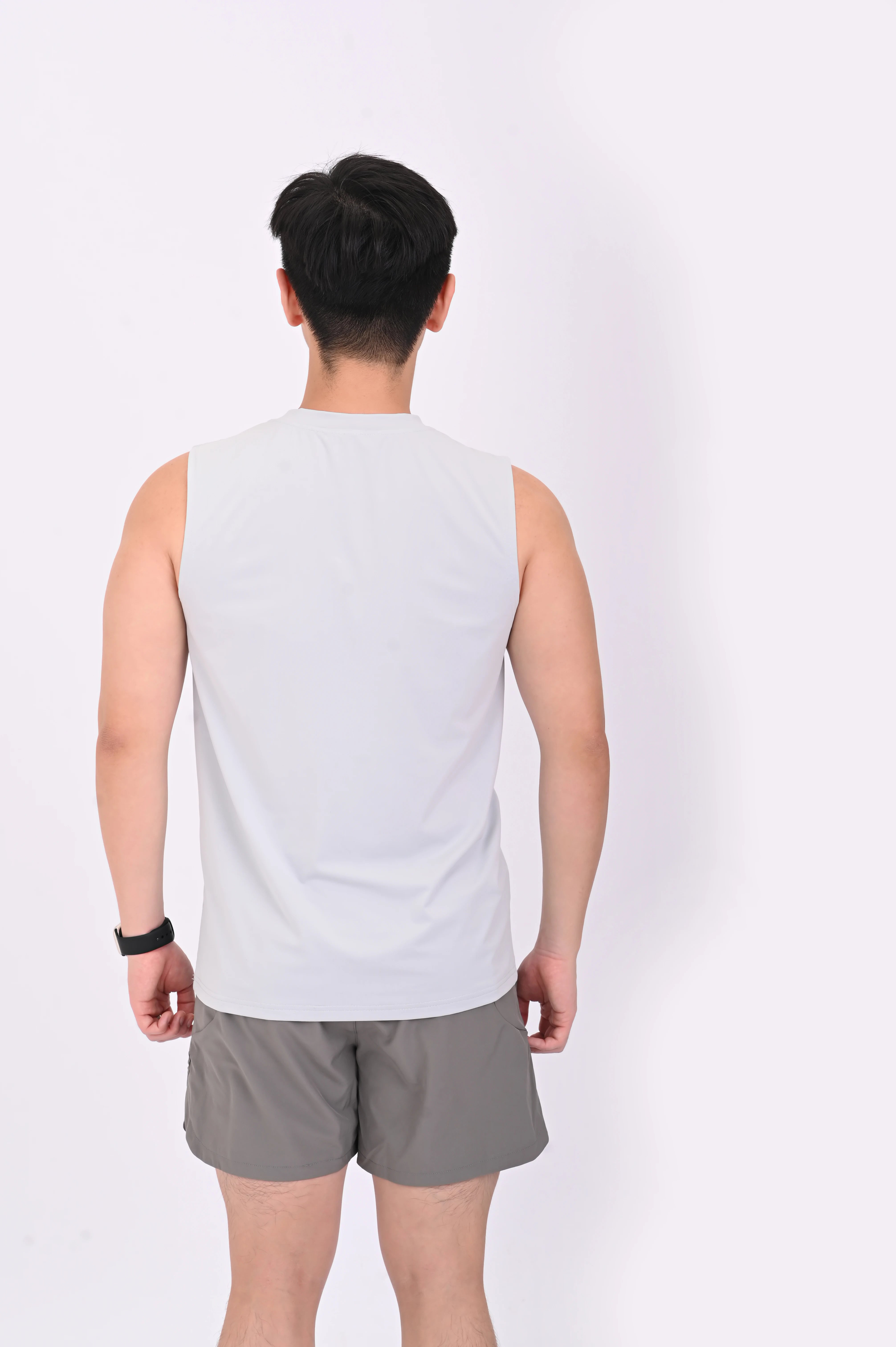 Back view of a person wearing a BELVYNN premium gray tank top and gray pants on a white background