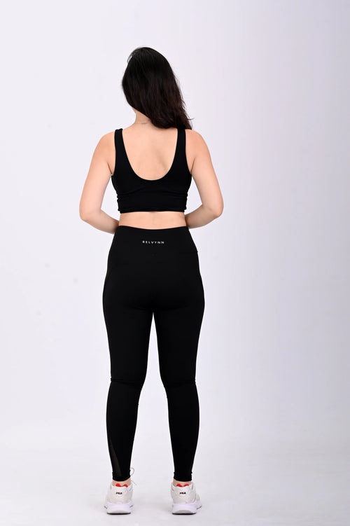 Back view pose of a person wearing a BELVYNN premium black athletic outfit with visible brand logo on a white background