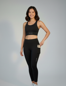 Close-up of BELVYNN Cropped Asian Fit Black Leggings on a model, showing the side pocket, the precision ankle hem and high-density technical fabric.