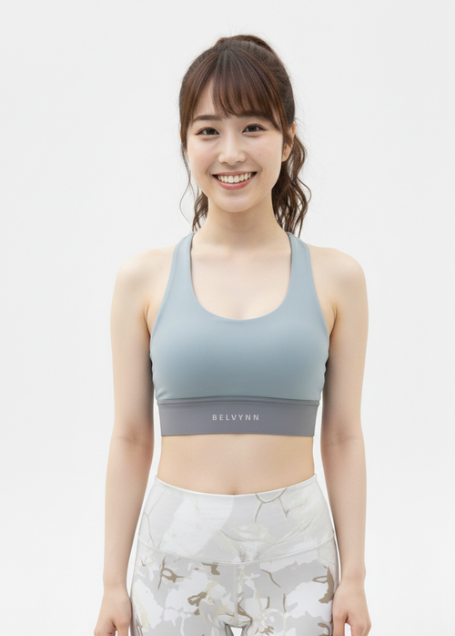 Close up view of a model wearing the BELVYNN Signature Women's Blue Top in a minimalist studio, featuring a refined fit and luxury performance fabric.