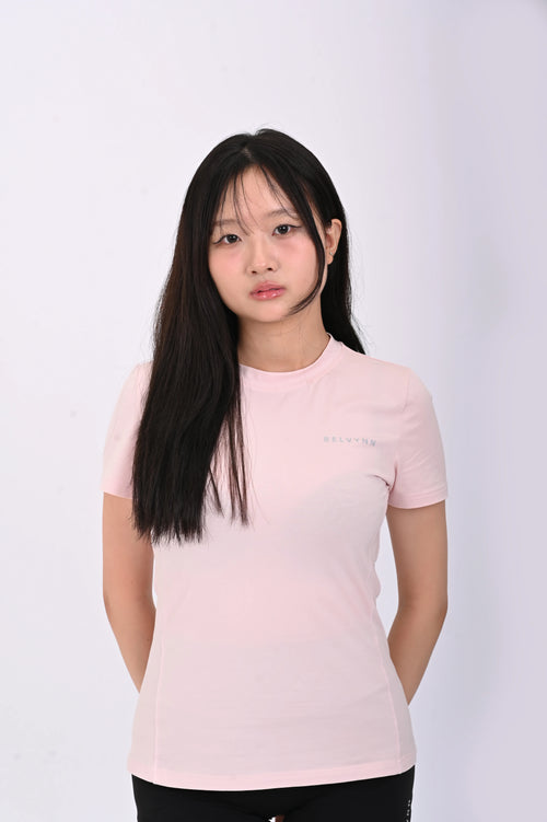 Close up view of a person wearing a BELVYNN premium pink t-shirt and black shorts on a white background