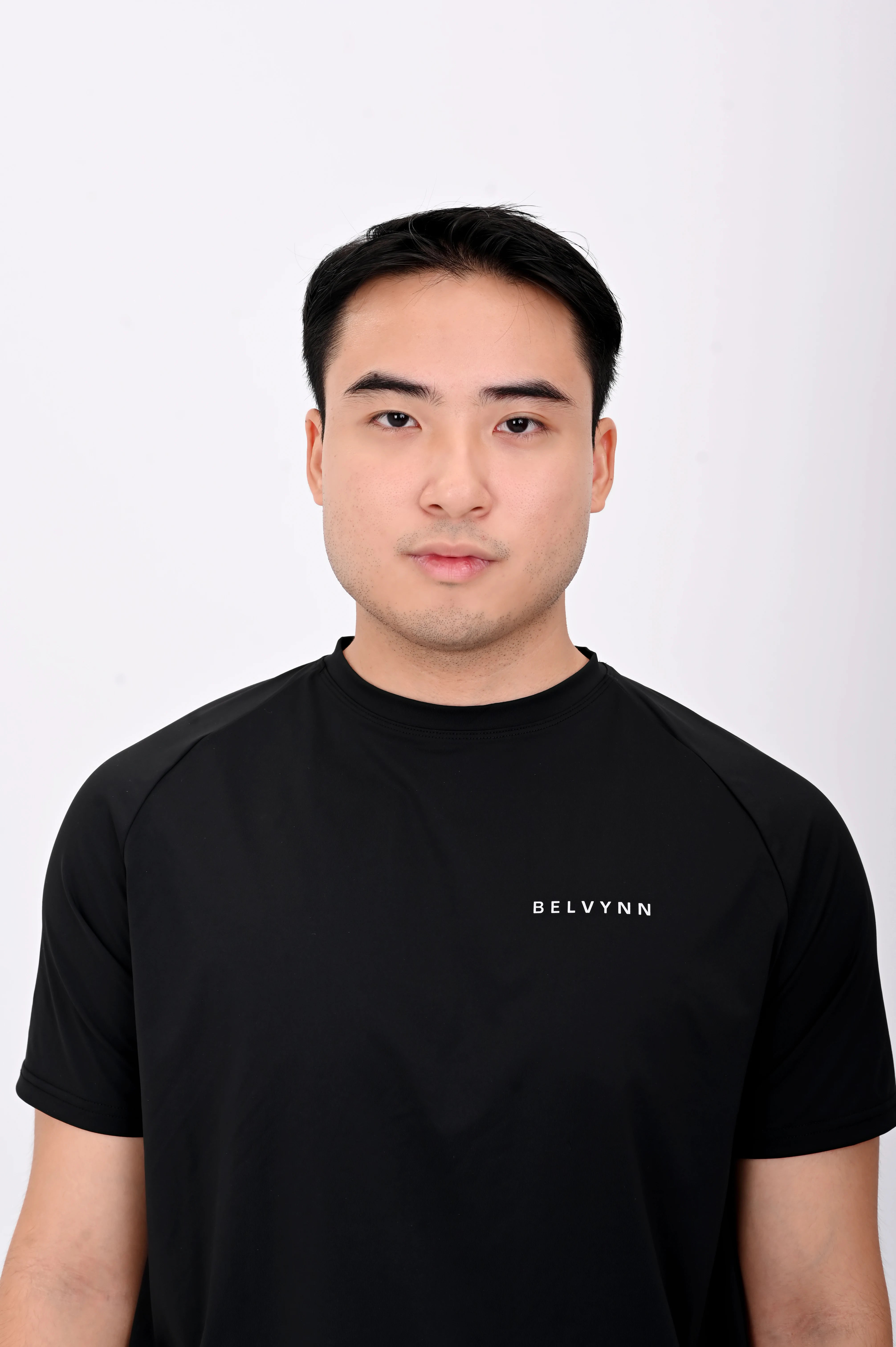 Close up view pose of a person wearing a BELVYNN premium Black t-shirt and black shorts on a white background