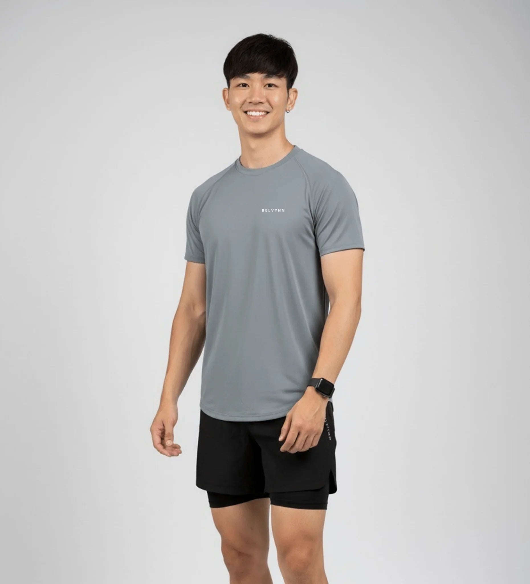 Front view of a male athlete wearing the BELVYNN Men’s Performance T-shirt in gray, highlighting the V-taper silhouette and climate-tech moisture management.