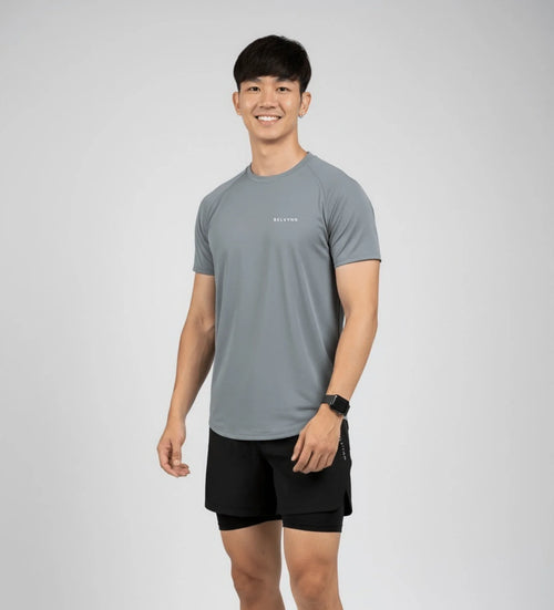 Front view of a male athlete wearing the BELVYNN Men’s Performance T-shirt in gray, highlighting the V-taper silhouette and climate-tech moisture management.