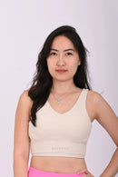 Front view of a person wearing a BELVYNN premium cream white sports bra on a white background