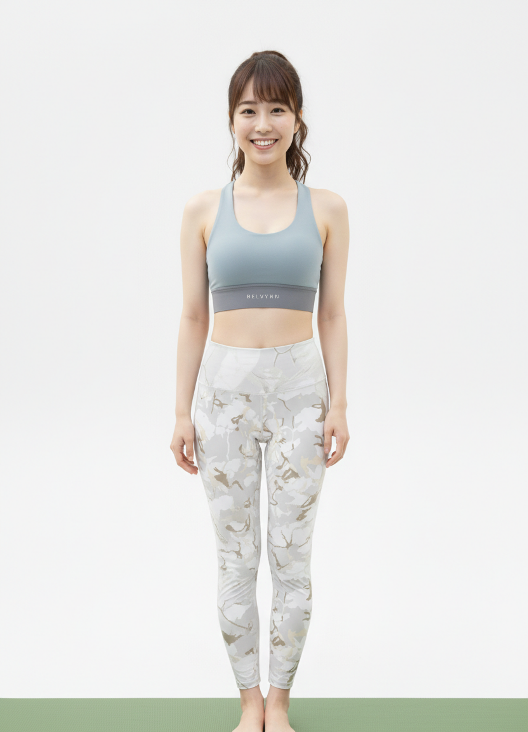 Full view of a model wearing the BELVYNN Signature Women's Top and pants in a minimalist studio, featuring a refined fit and luxury performance fabric.
