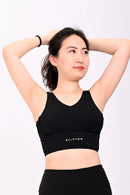 Woman wearing a BELVYNN premium black athletic outfit with a visible brand logo on a white background